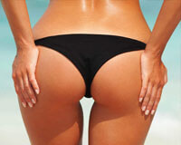 Picture of a woman feeling her rounded buttocks filled with fat transfer